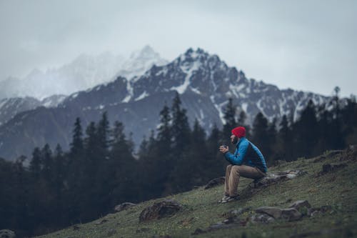 Foto Dell'uomo Seduto Sulla Roccia