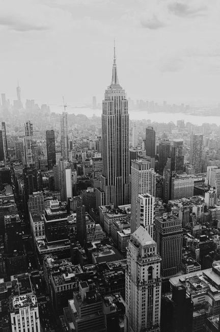 Aerial black and white view of New York City skyline featuring the Empire State Building.