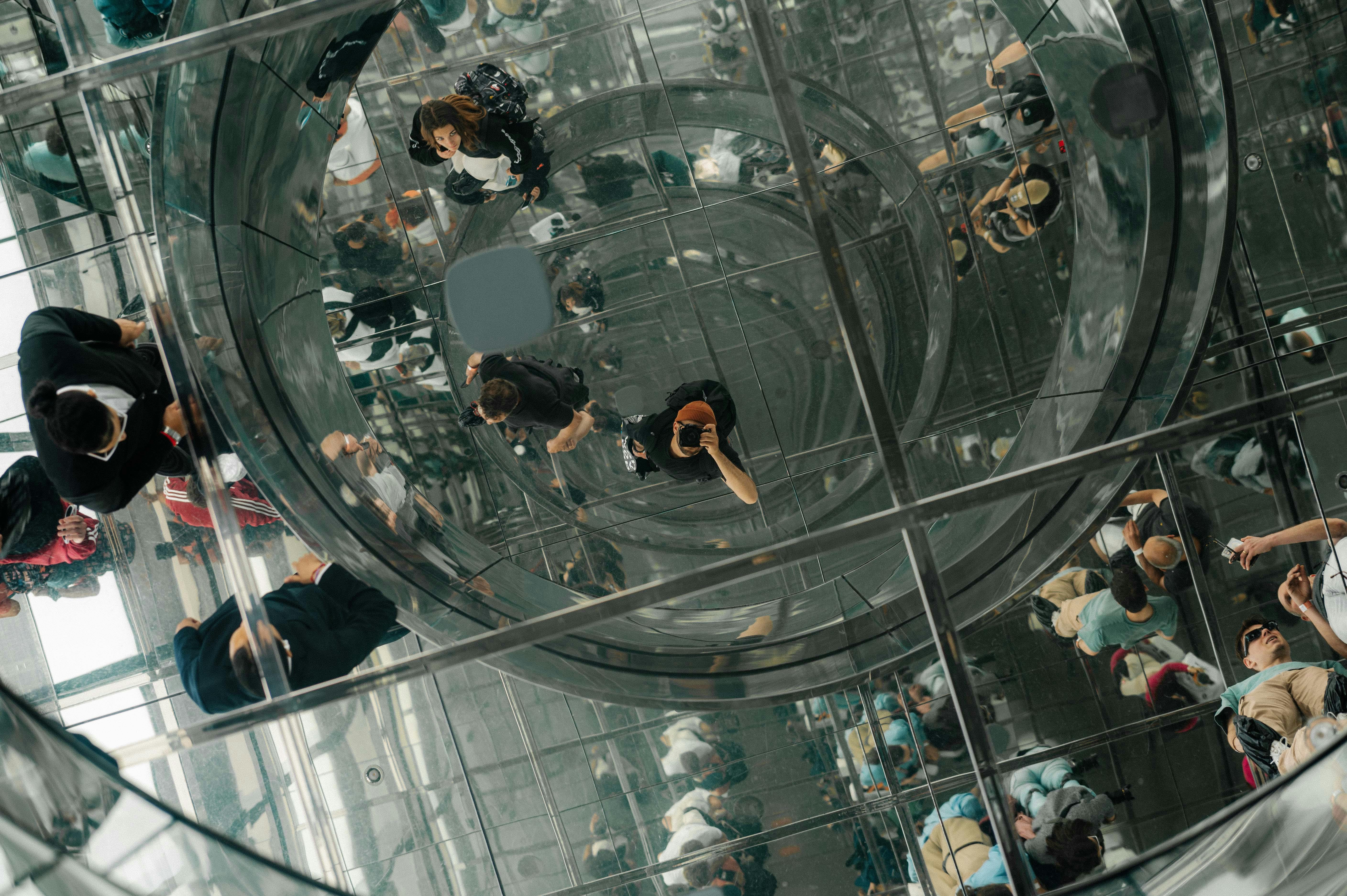 a man taking a picture in the reflection on the ceiling in summit one vanderbilt new york city