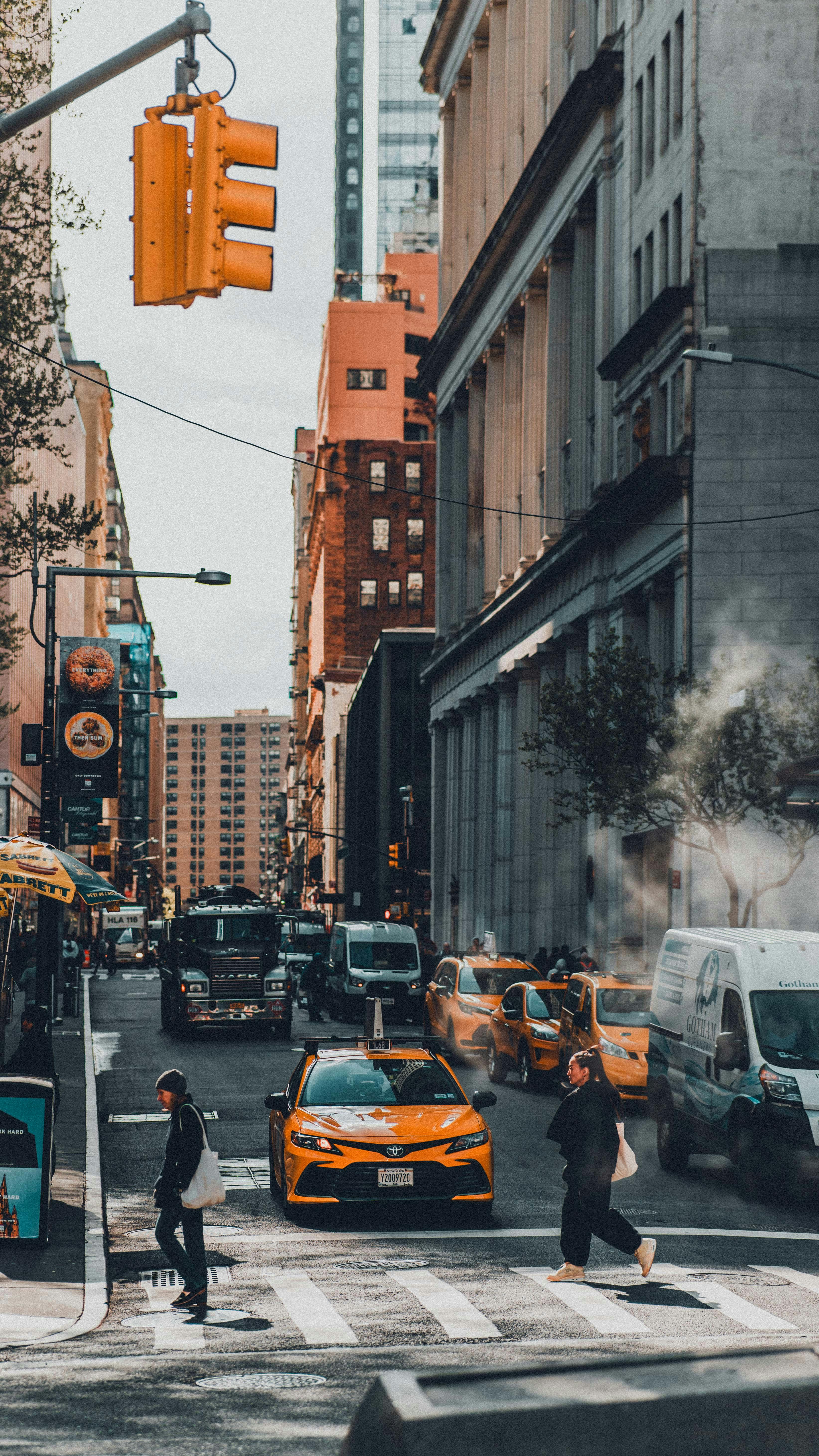 Urban life in New York City featuring pedestrians, taxis, and skyscrapers.