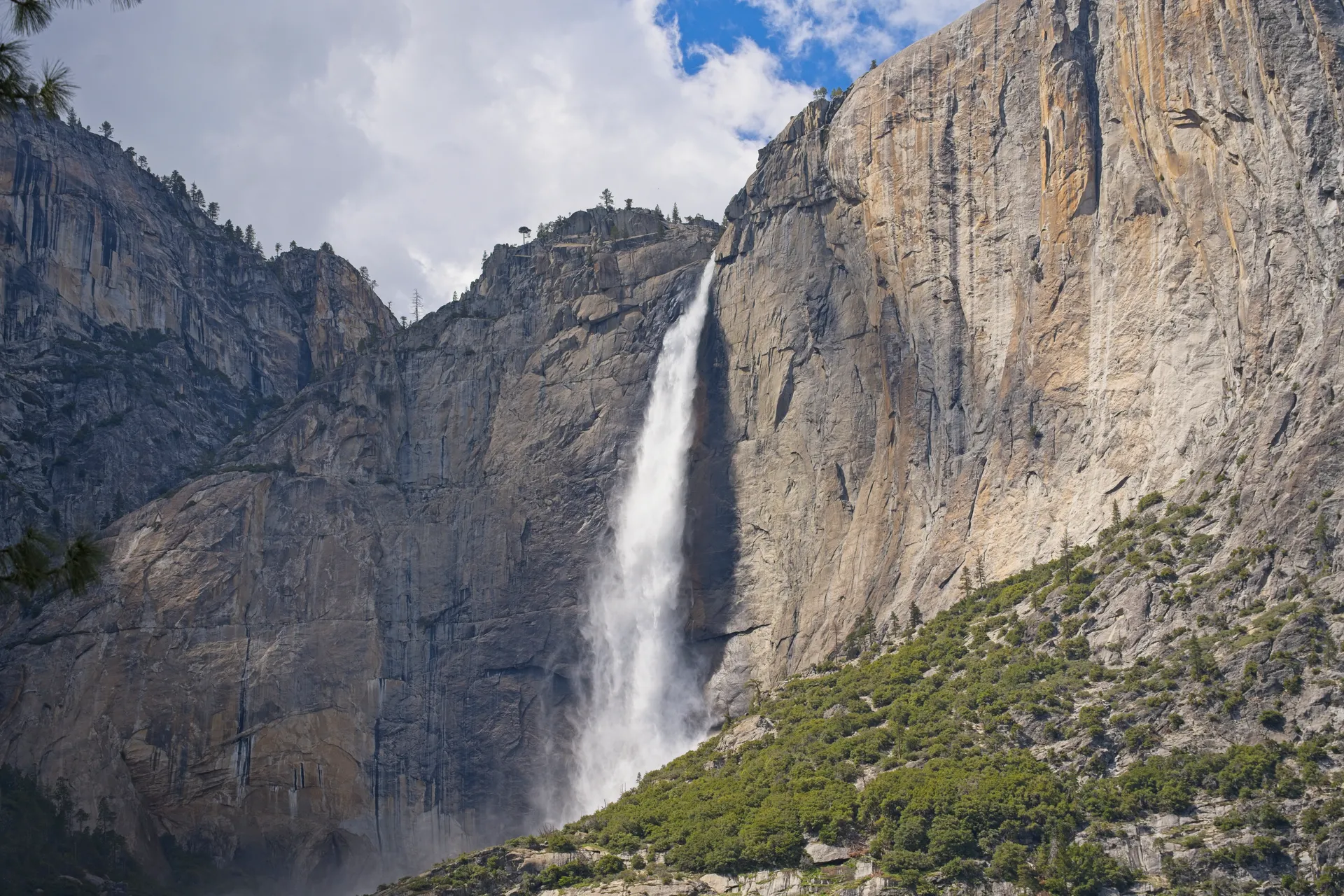View of Yosemite Falls cascading down rocky cliffs in Yosemite Valley, CA. View of Yosemite Falls cascading down rocky cliffs in Yosemite Valley, CA.