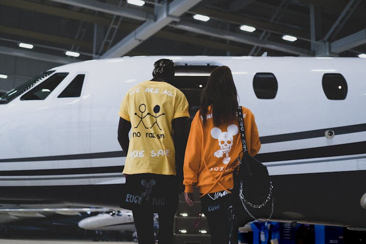 Man And Woman Standing Beside Private Plane