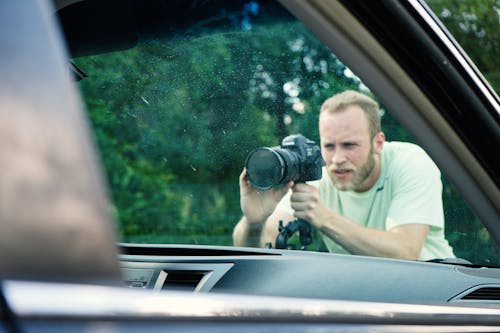 Man Taking Photo Near Vehicle