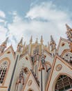 从低角度仰望哥特式教堂立面，明亮的蓝天映衬下，其复杂的建筑结构令人惊叹