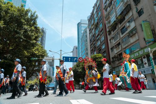 Free Colorful parade procession walking through bustling city streets under a clear sky. Stock Photo