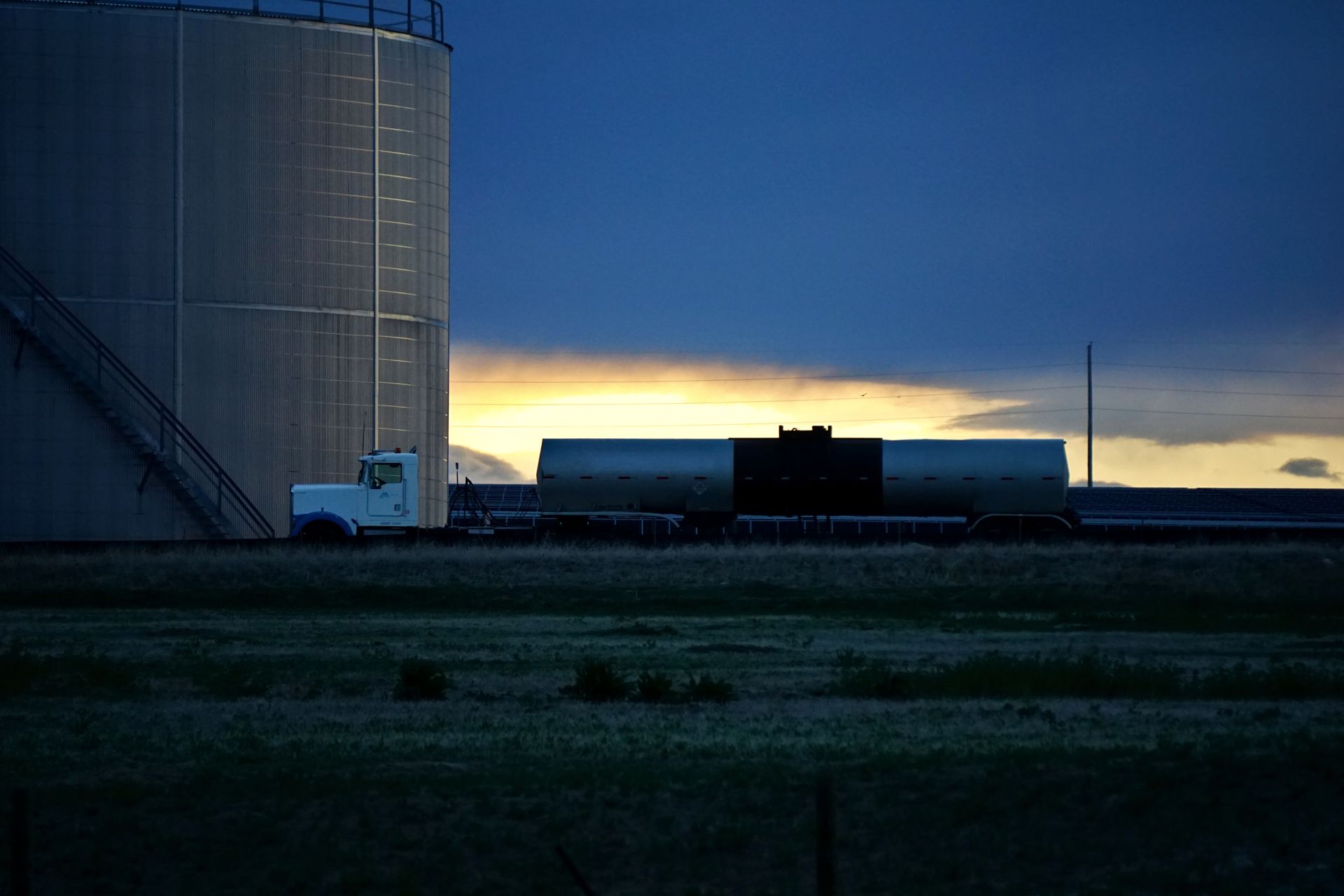 A storage tank farm with diesel reservoirs at sunset