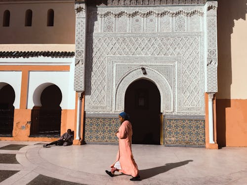 Person Walking Beside Mosque