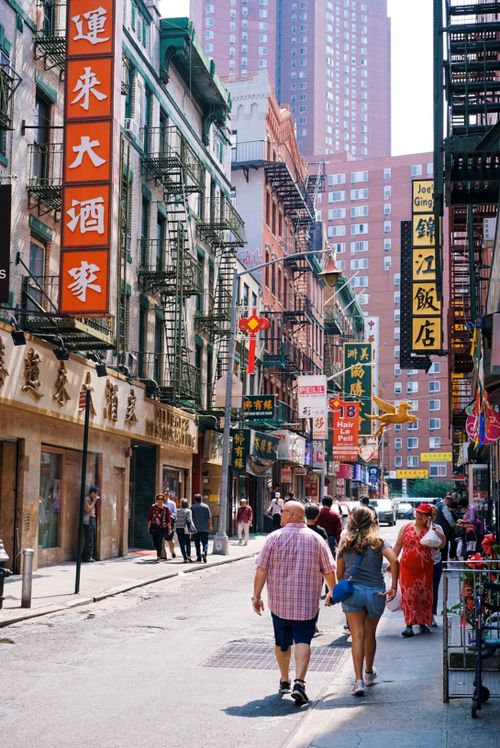 Free Colorful street scene in Chinatown with people walking and prominent signages. Stock Photo