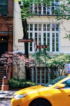 一辆黄色出租车飞驰过格拉梅西公园迷人的街道，捕捉着城市生活的瞬间