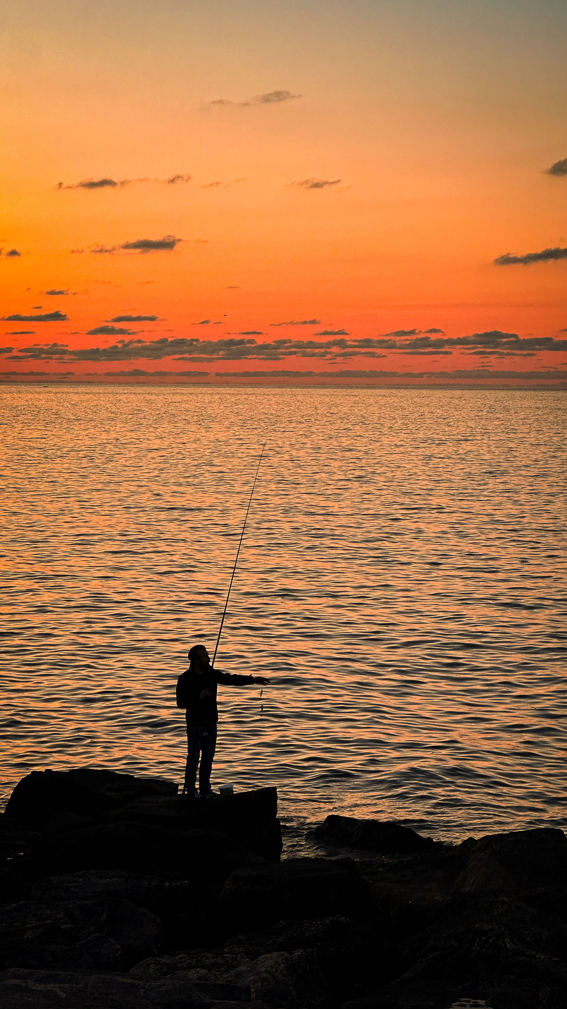 Silhouette of Fisherman on Sea Shore at Sunset · Free Stock Photo