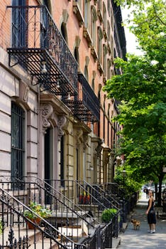 一排带有铸铁细节的标志性褐砂石建筑，矗立在阳光明媚的城市街道上