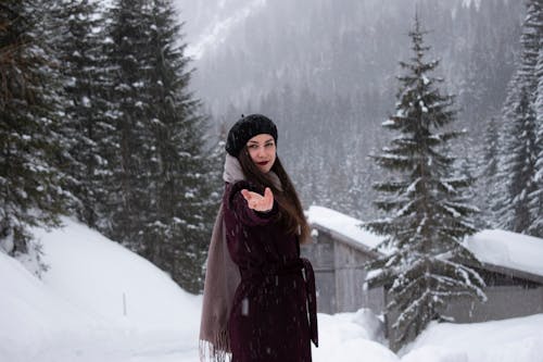 Woman on Snow Covered Area Near House