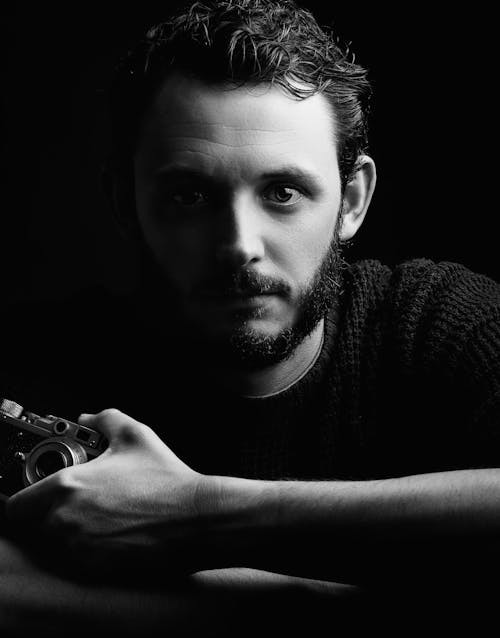 Grayscale Portrait Photo of Man Wearing Holding a Camera