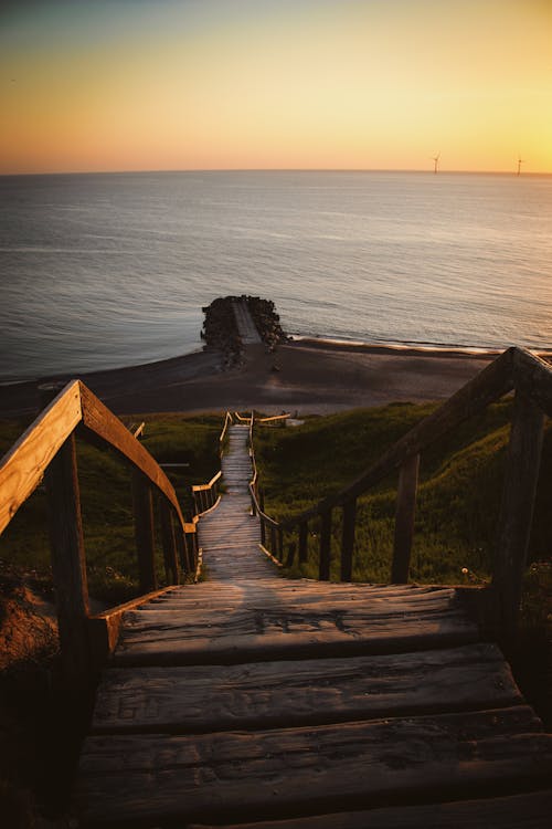 A wooden staircase leading to the beach at sunset