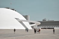 游客白天探索巴西利亚标志性国家博物馆的未来派外观