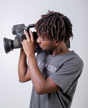 A young adult focused on photography using a professional camera indoors.