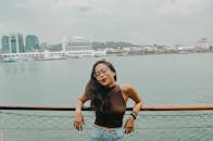 一位快乐的戴眼镜女人在码头海滨享受着宁静的时刻，拥抱这一天