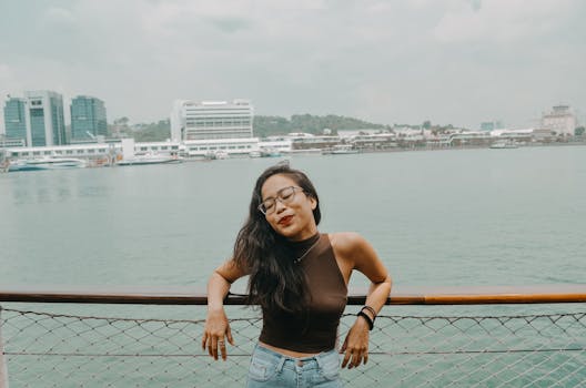 一位快乐的戴眼镜女人在码头海滨享受着宁静的时刻，拥抱这一天