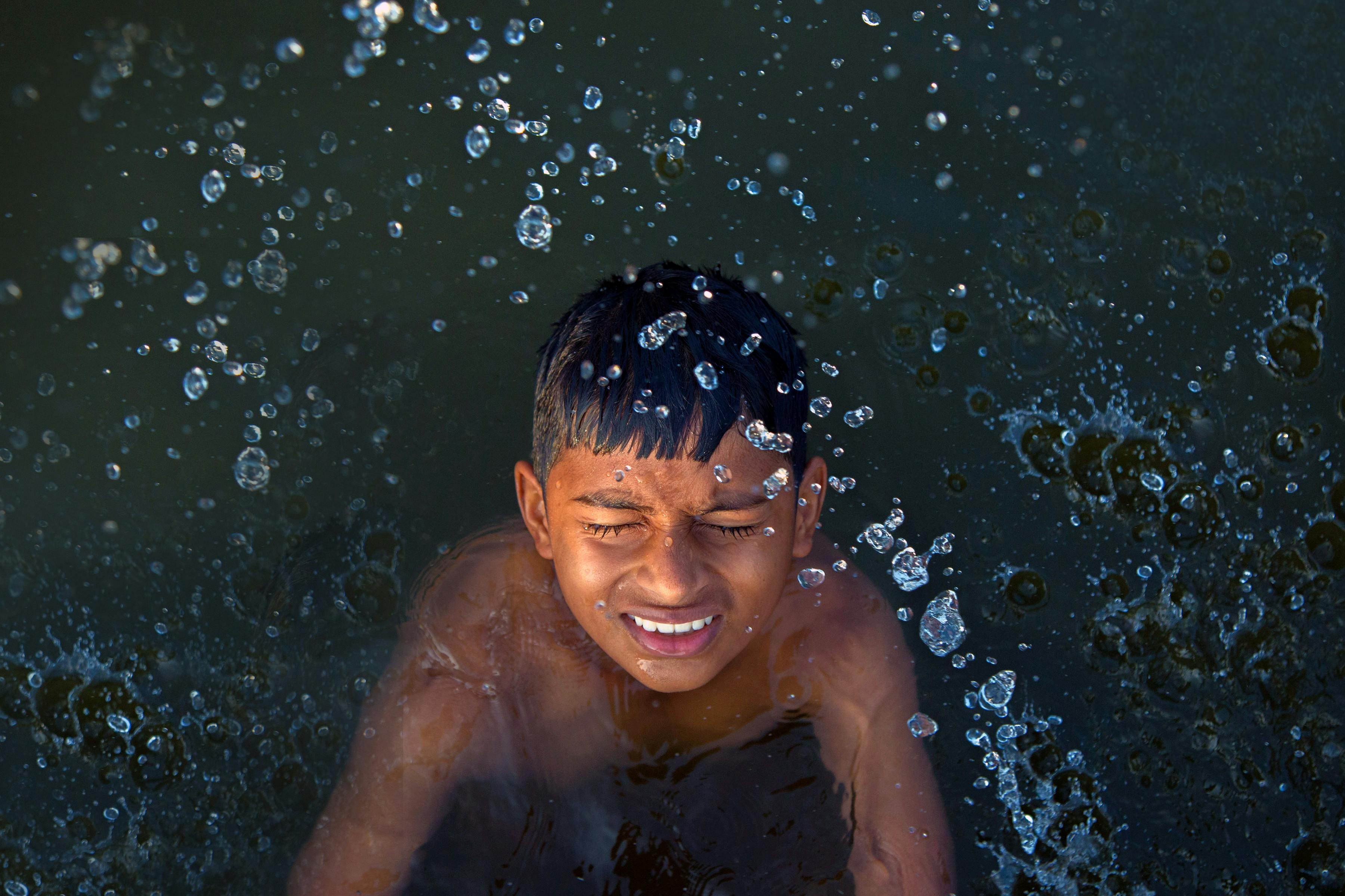 boy swimming on body of water