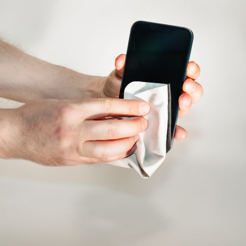 Free Hands cleaning smartphone screen with a soft cloth, emphasizing hygiene and device care. Stock Photo