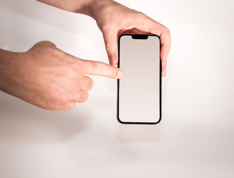 Hand pointing at blank smartphone screen, ideal for app mockups and technology concepts.