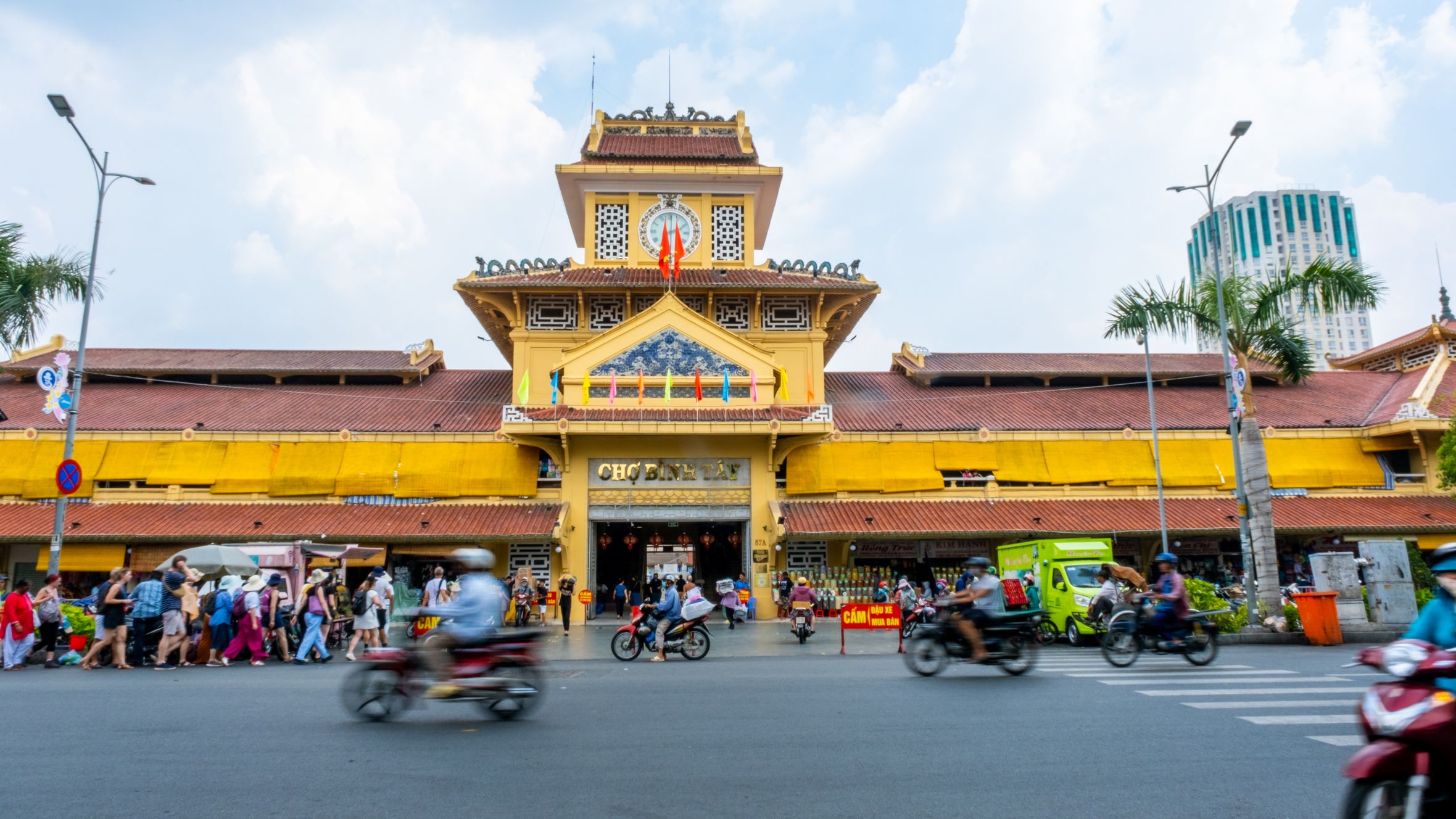 Vibrant scene outside Binh Tay Market in Ho Chi Minh City, capturing lively street activity.