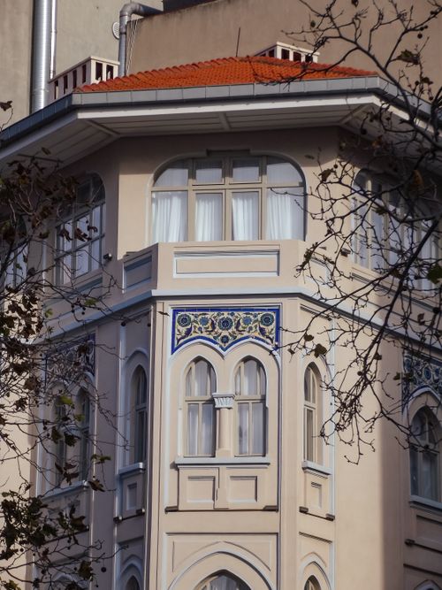 Free Close-up of a decorated residential building featuring arched windows and intricate floral patterns. Stock Photo
