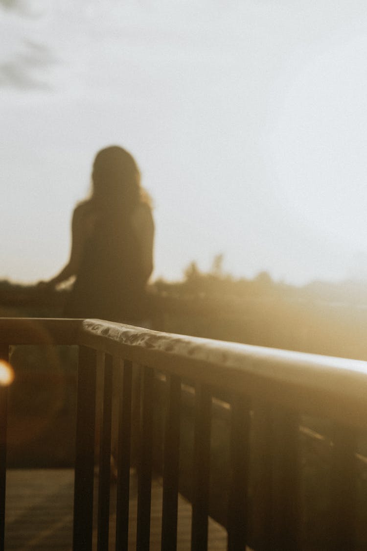 Silhouette Of Person Standing On Balcony