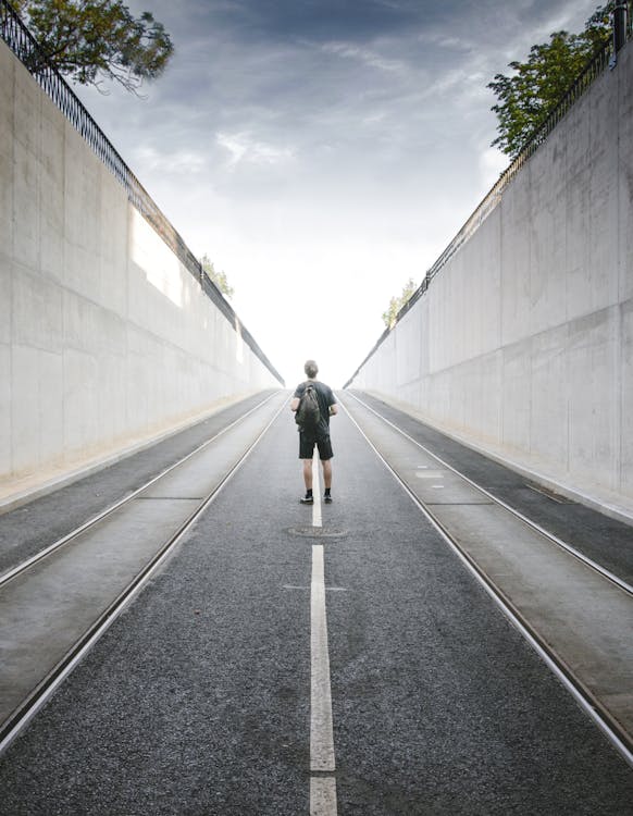 Free Backview of a man man standing in the middle of the road Stock Photo