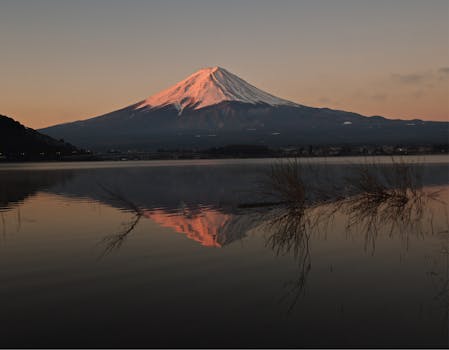 Scenic view of Mount Fuji with a dawn reflection on the lake, capturing nature's beauty.