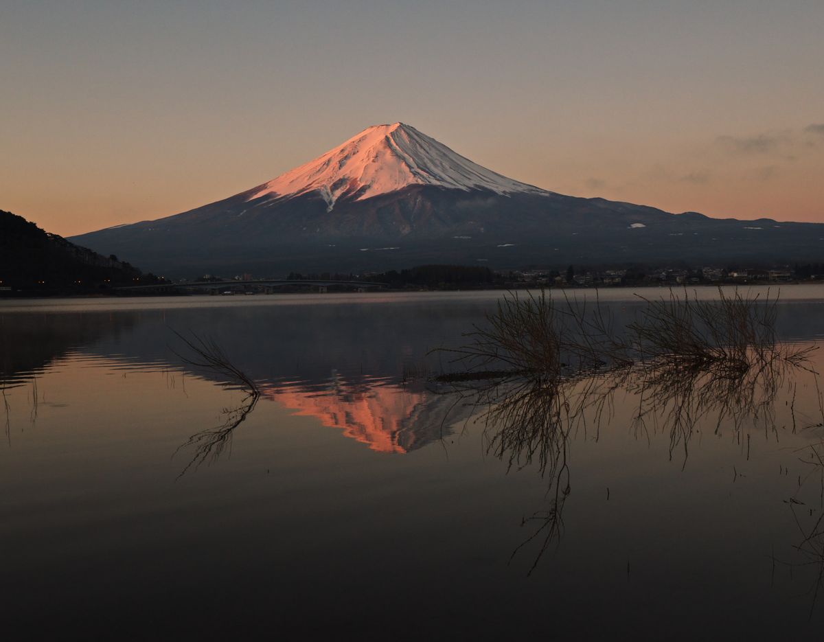Mount Fuji reflected in a calm lake at sunrise