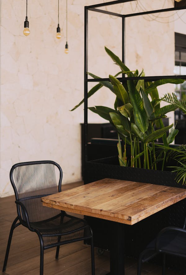 Brown Wooden Table in Front of Green Leafed Plant