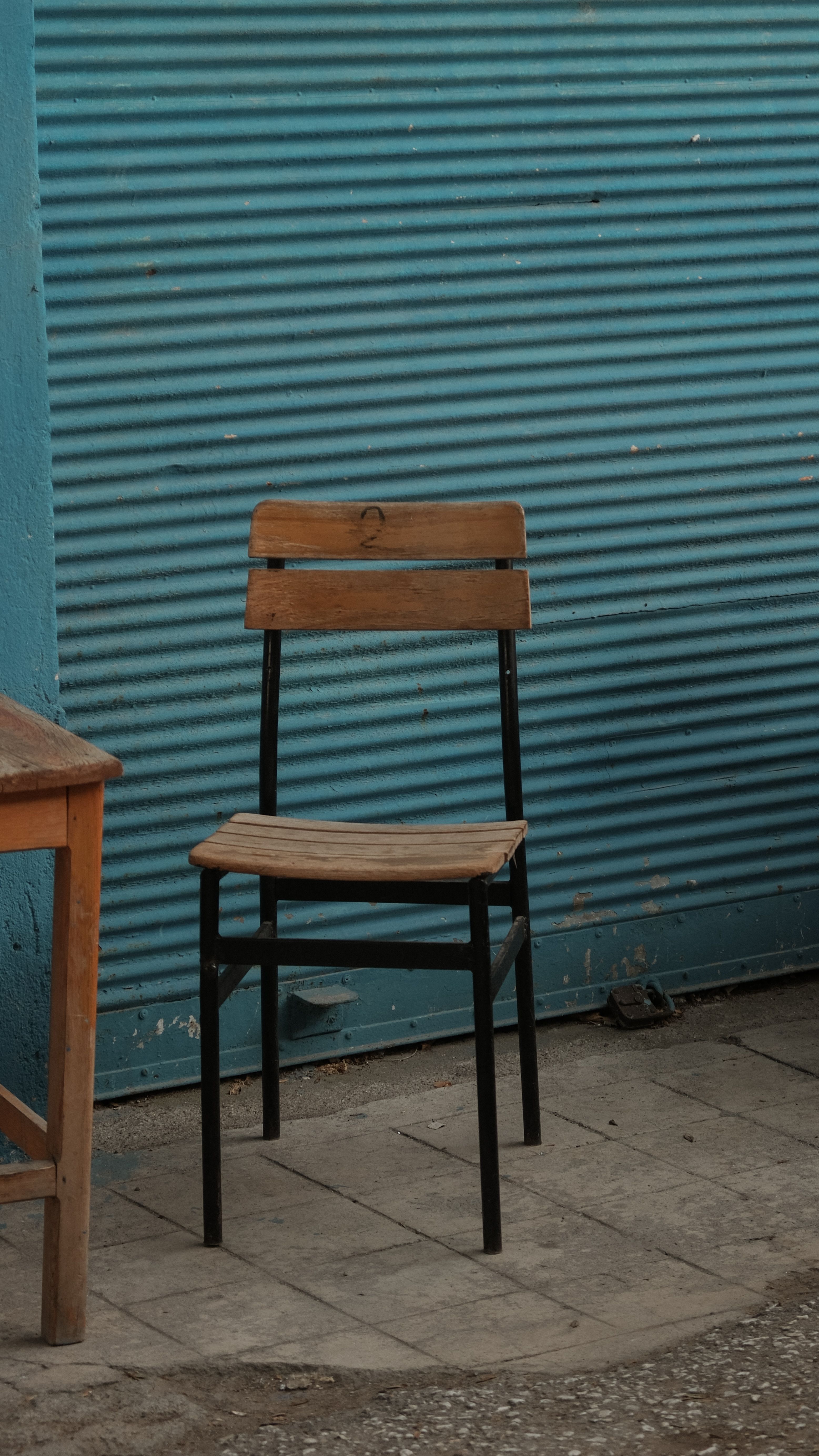 Simple Chair on a Sidewalk in Front of Blue Exterior Roller Shutters ...