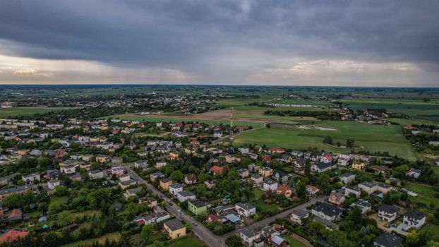 Drone capture of a sprawling countryside town under a dramatic stormy sky.