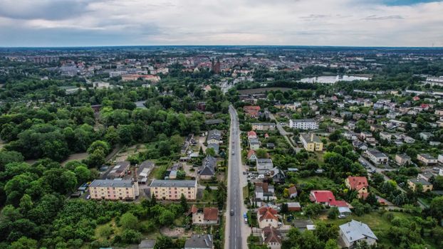 Aerial shot of a vibrant town with greenery, roads, and buildings offering a peaceful urban landscape.