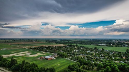 Free Aerial view showcasing vast fields and a town under dramatic skies, capturing rural tranquility. Stock Photo