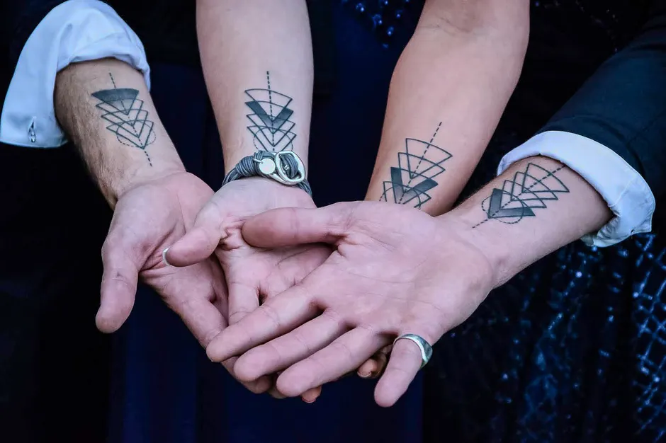 Tatouages de couple assortis au motif géométrique identique sur les avant-bras
