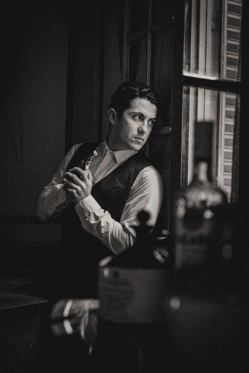 Free Black and white portrait of a man in 1920s attire gazing out a window. Stock Photo
