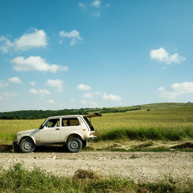 Explore off-road adventures with a vintage SUV on rural dirt roads under a clear sky.