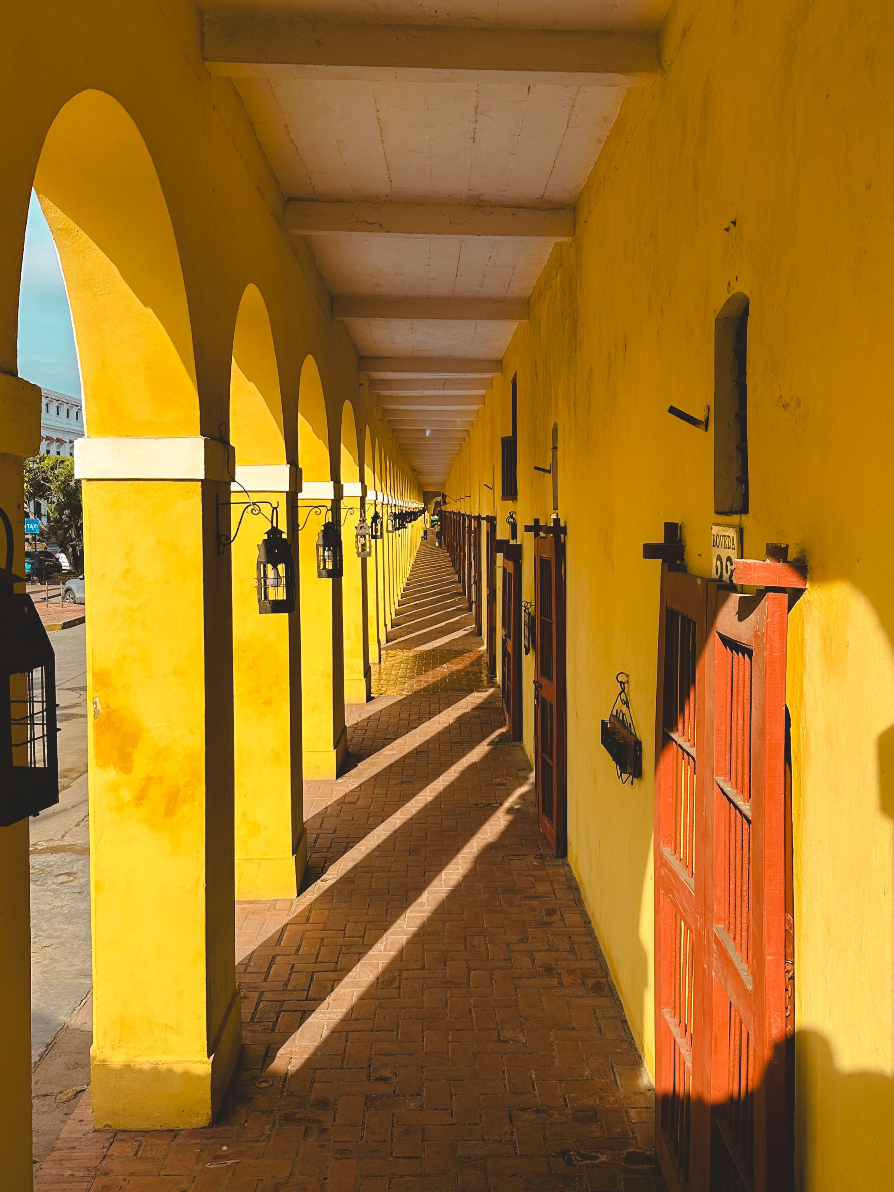 Yellow Colonnade with Doors and Lamps · Free Stock Photo