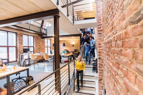 Photo De Femme En Haut Jaune Marchant Dans Les Escaliers Dans Un Bureau