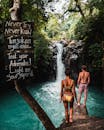 一对夫妇在巴厘岛壮观的瀑布前相拥，感受着冒险与自然
