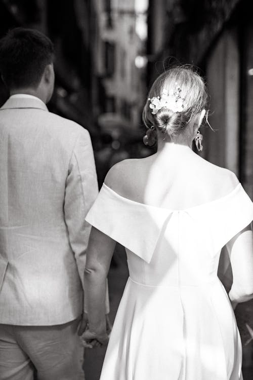 A bride and groom walking down a street