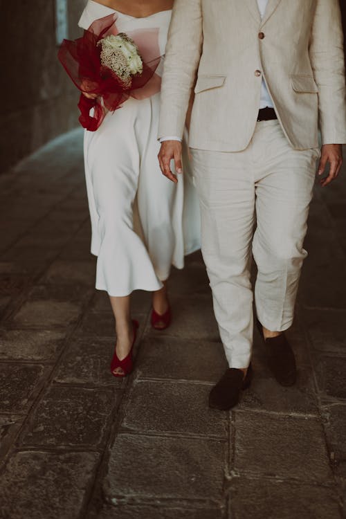 A bride and groom walking down a stone path