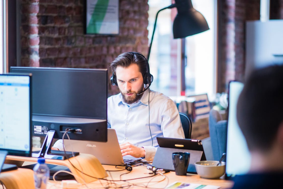 Selective Focus Photo of Man in Official Shirt  Sitting in Office  Working on Laptop