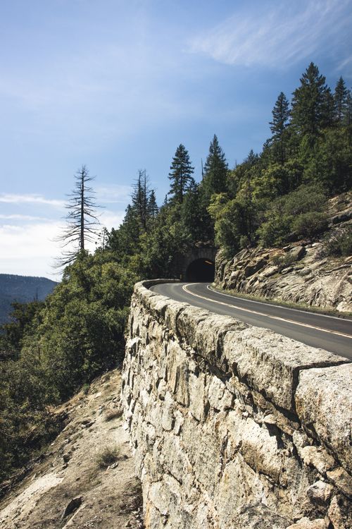 Free Winding road through the forest leading to a tunnel in Yosemite National Park. Stock Photo
