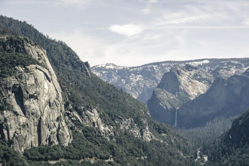Free A stunning view of Yosemite Valley featuring majestic cliffs and lush greenery. Stock Photo