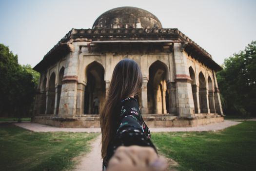 A woman captures a selfie with a historic dome building in the background, showcasing a blend of architecture and tourism.