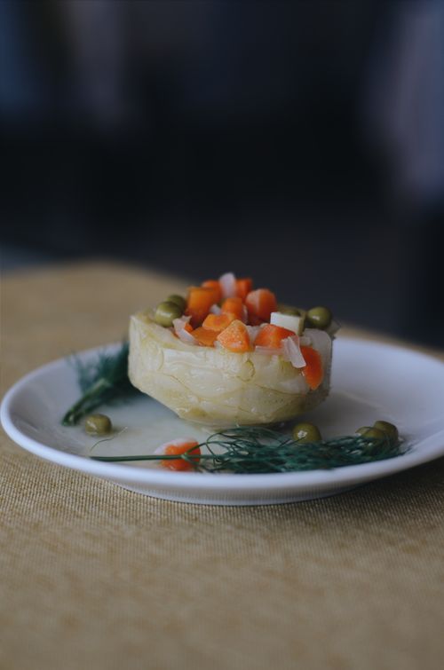 Free Gourmet artichoke heart topped with diced carrots and peas on a white plate. Stock Photo