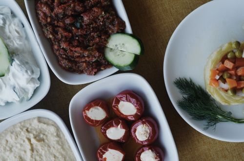 Free A selection of Mediterranean appetizers with cream cheese, roasted peppers, and fresh vegetables on plates. Stock Photo